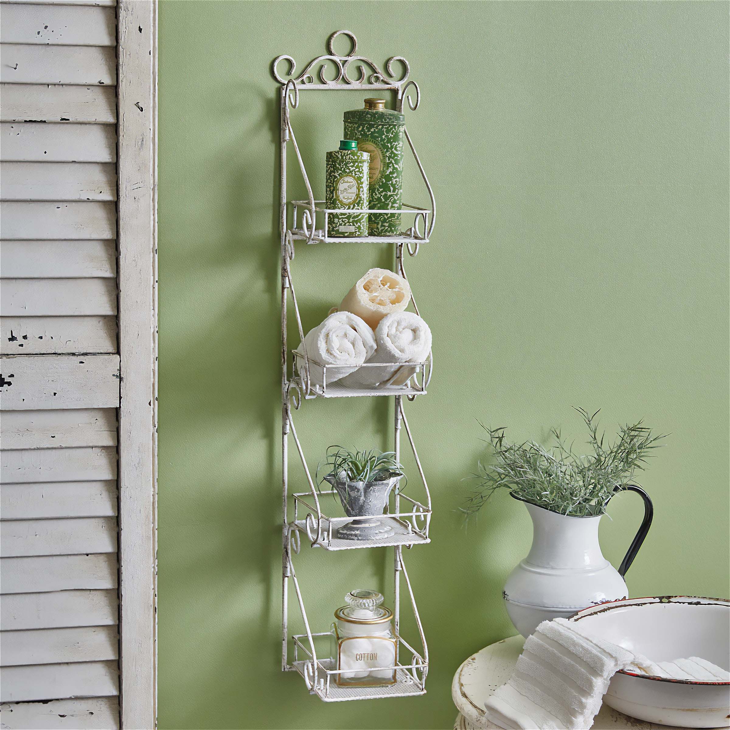 Vintage bathroom wall shelf with rolled towels and greenery, adding nostalgic charm to a serene green bathroom.