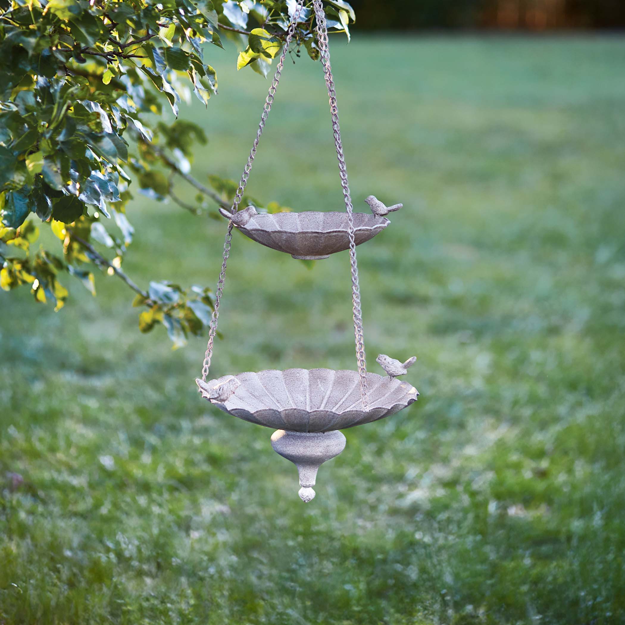 Vintage double-tiered bird feeder hanging in a garden, offering an antique style decor for attracting wildlife.
