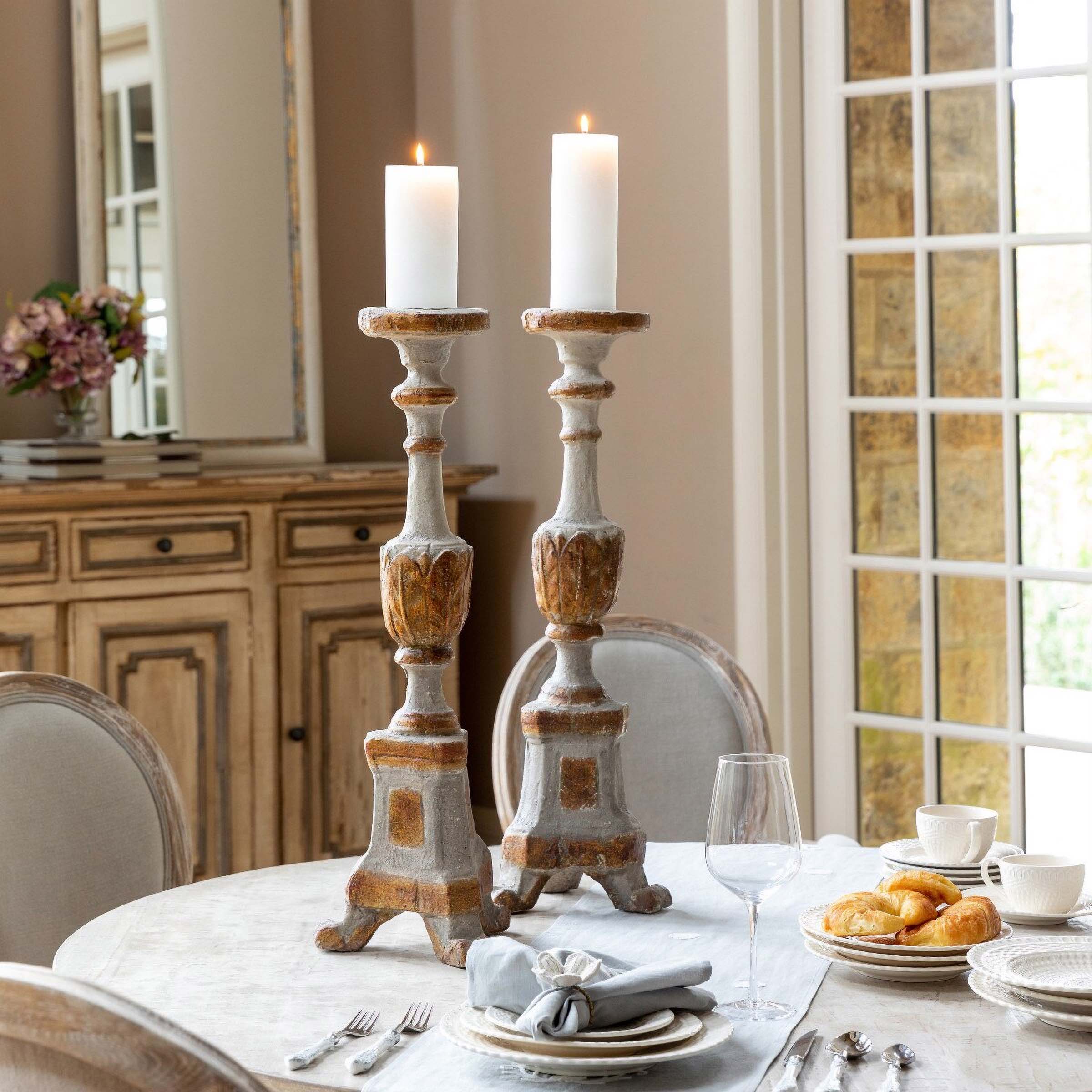 Elegant vintage candle holders on dining table, enhancing antique decor with a warm, inviting candlelight atmosphere.