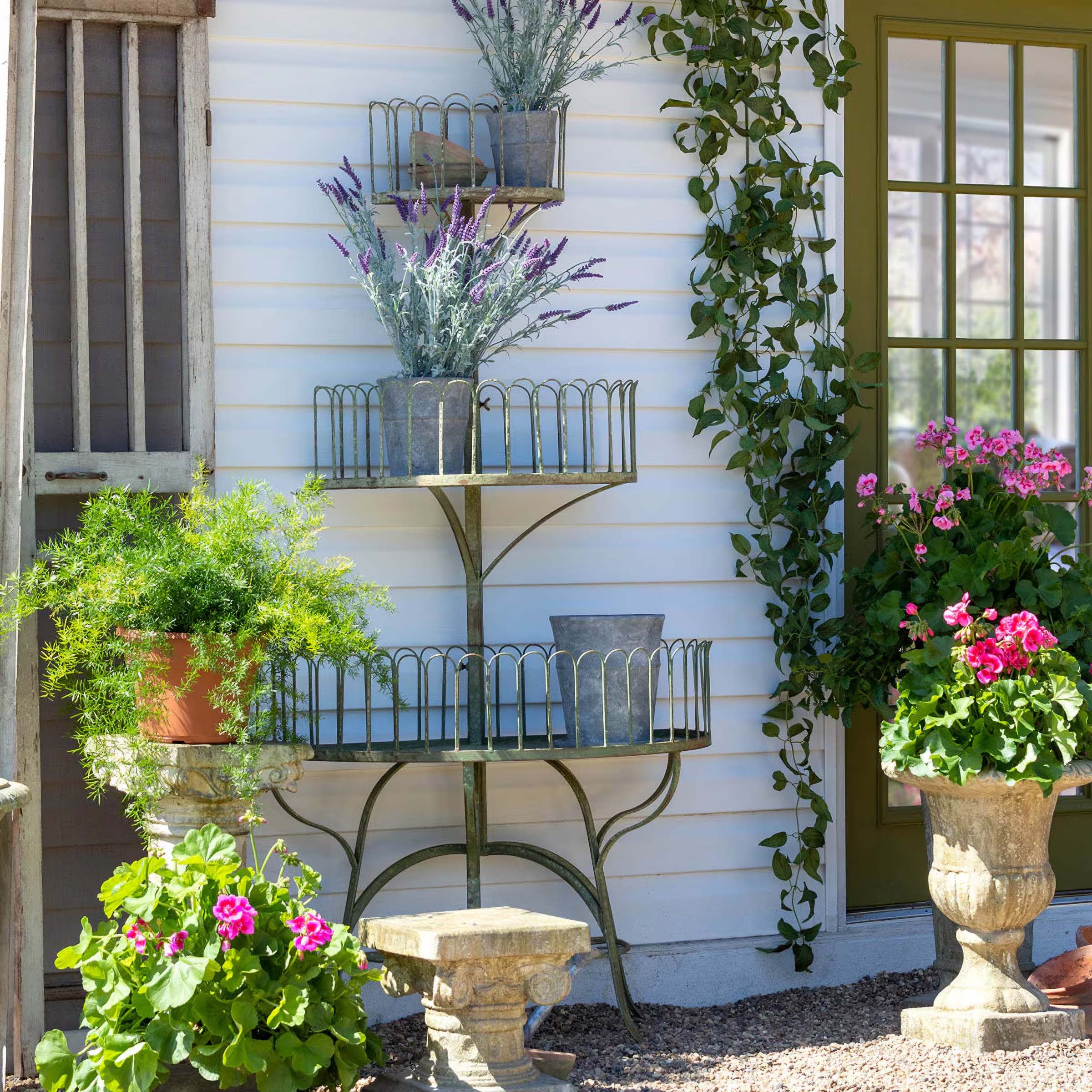 Vintage garden décor with tiered planters and vibrant flowers enhancing outdoor charm