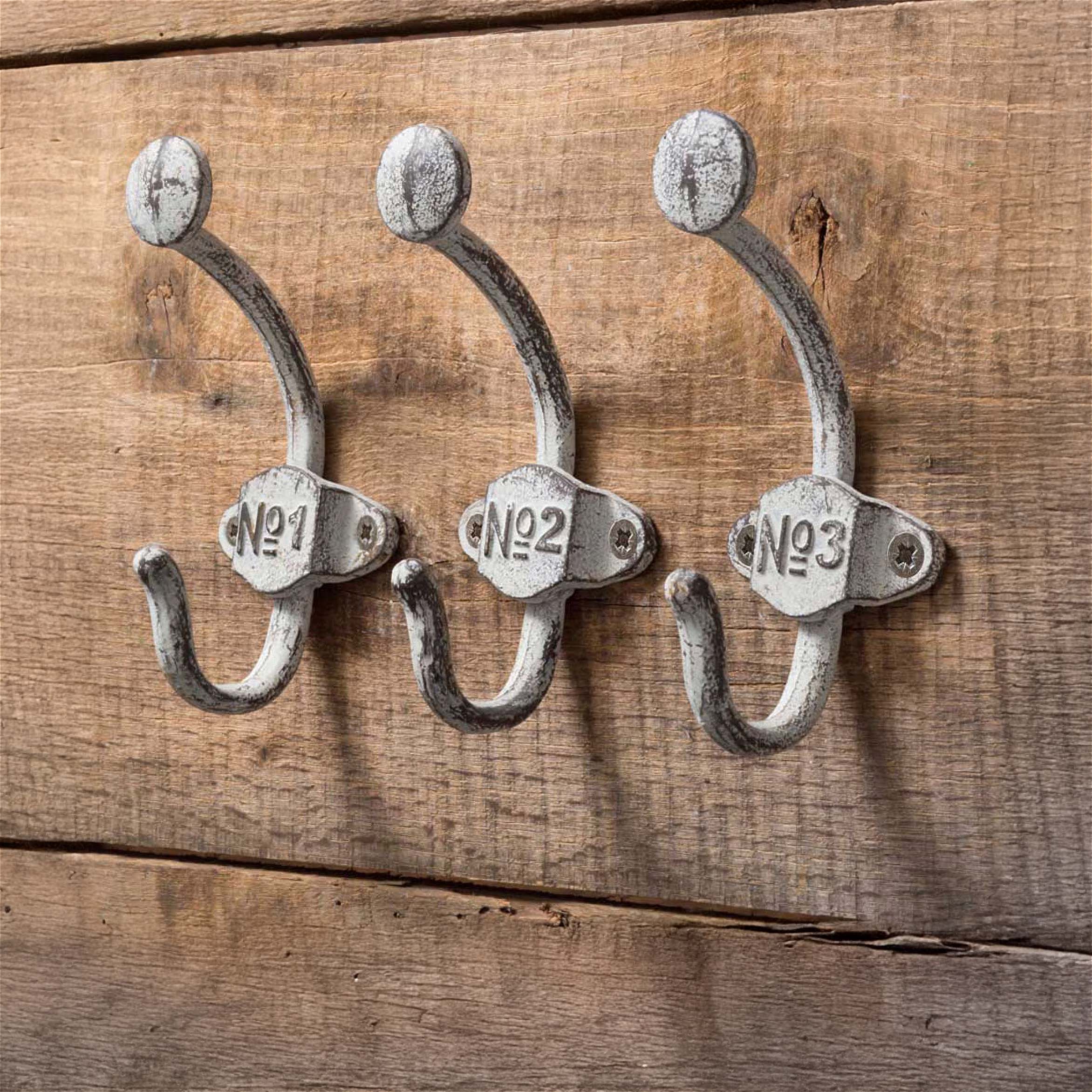 Vintage wall shelf with hooks holding kitchen towels and a herb plant, showcasing rustic charm and timeless craftsmanship