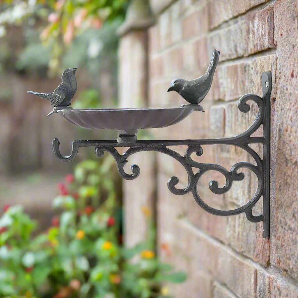 Antique-style wall-mounted bird feeder featuring decorative birds and elegant scrollwork.