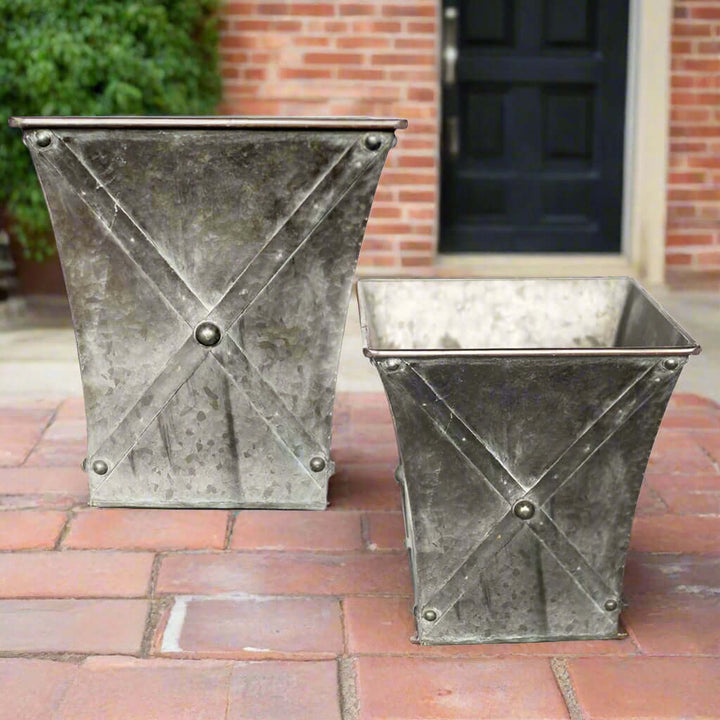 Set of 2 antique farmhouse galvanized metal square planters with hand-riveted detailing and weathered finish.