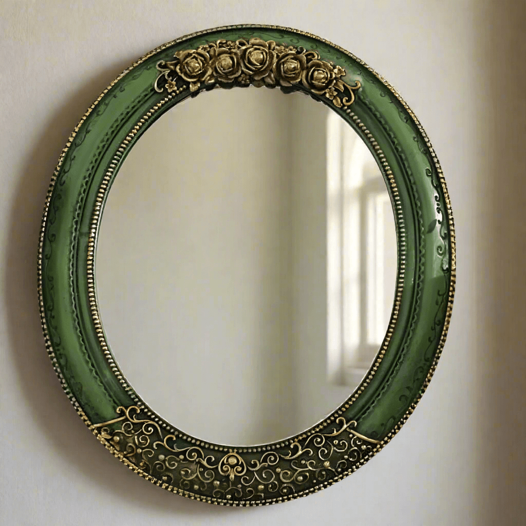 Antique green oval wall mirror with ornate gold detailing, adding vintage elegance to home décor.
