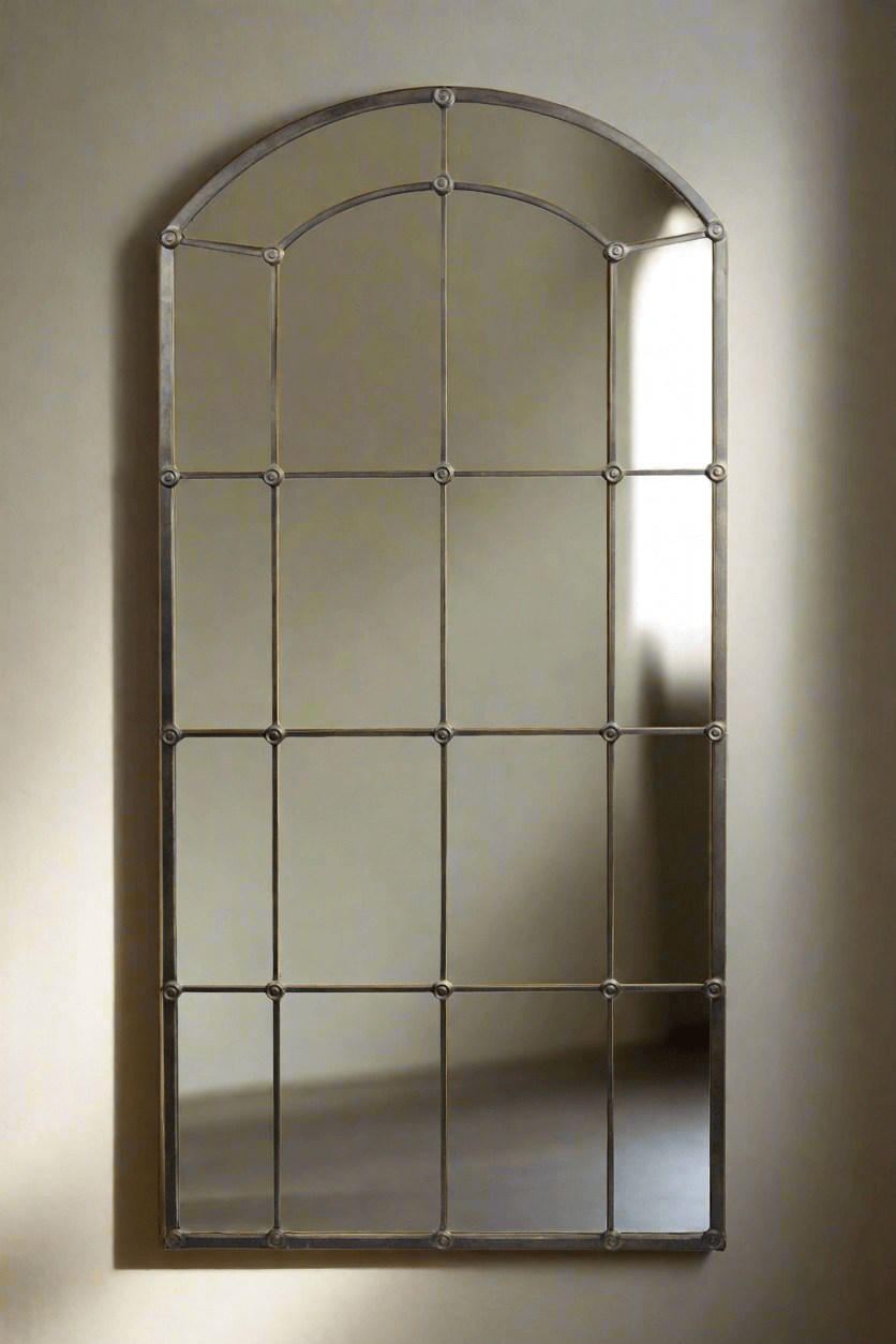 Arched Industrial Grid Wall Mirror with a vintage black metal frame, adding rustic elegance to any space.
