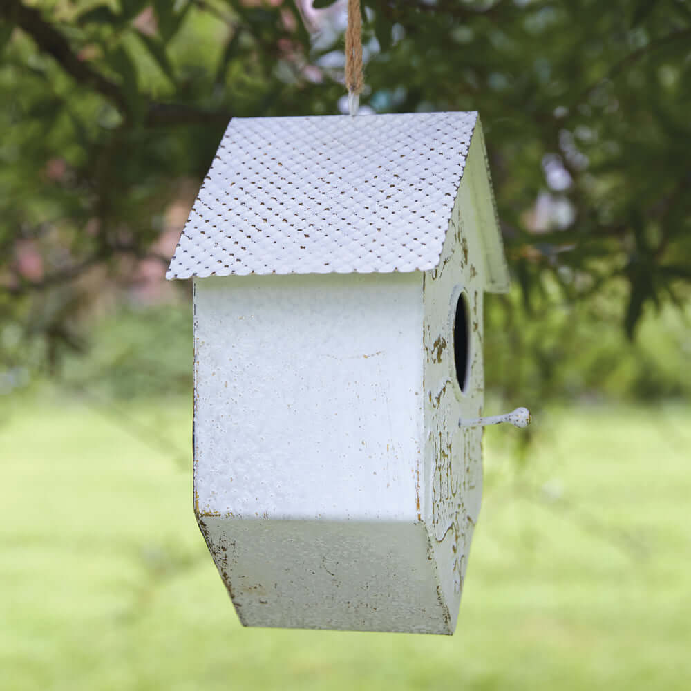 Cottagecore garden birdhouse with embossed filigree, white finish, hanging in a garden setting.