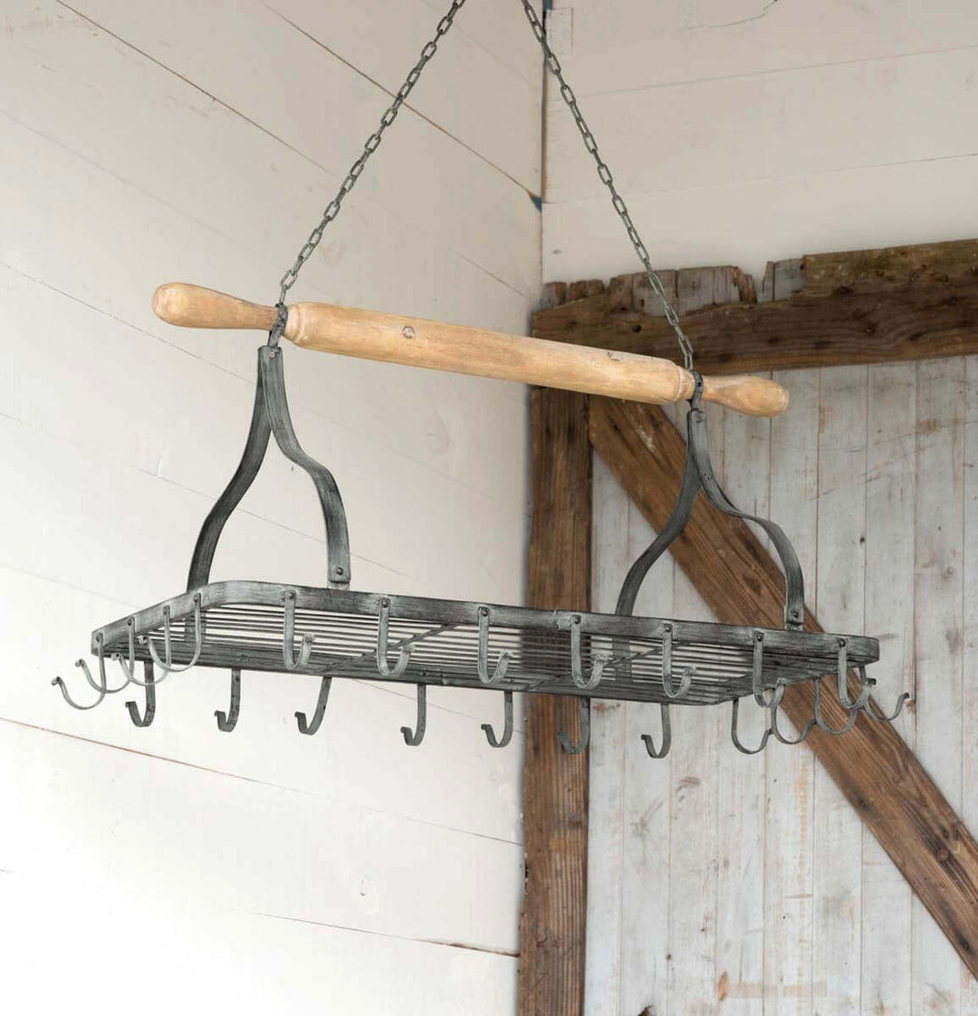 Farmhouse hanging pot rack with rustic iron hooks and wooden rolling pin, perfect for vintage kitchen decor.