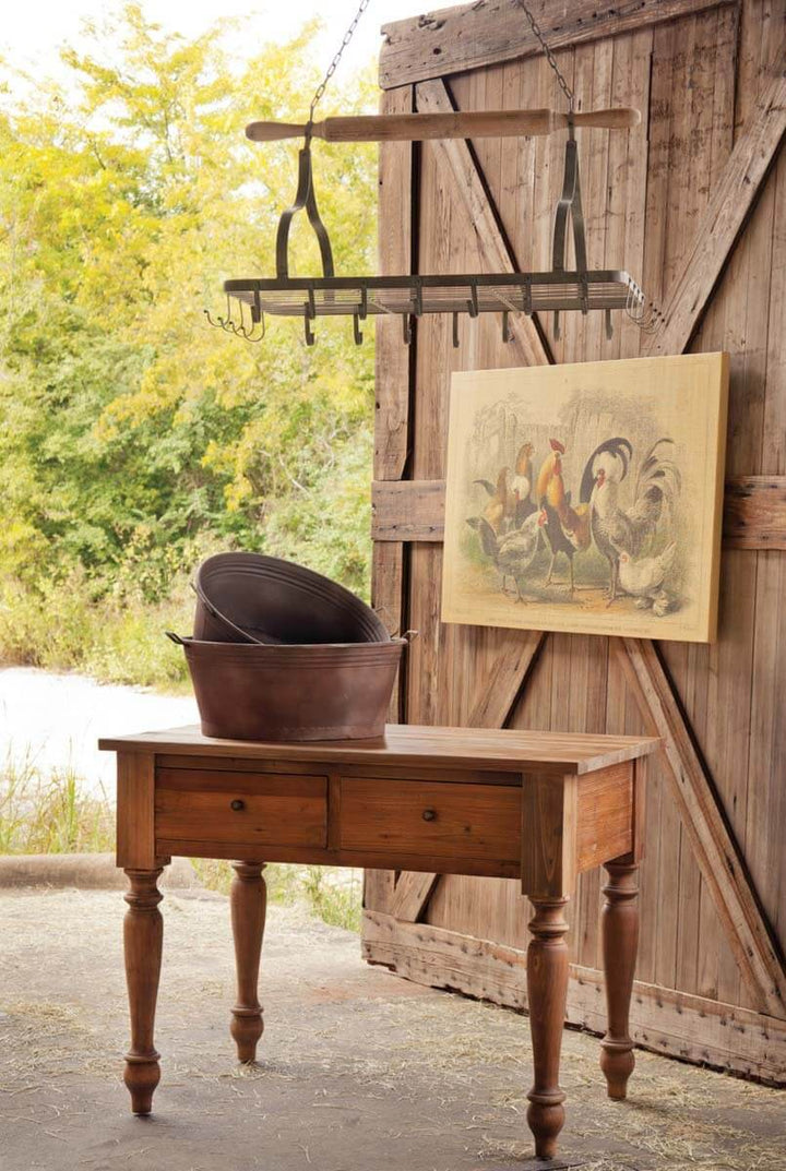 Farmhouse hanging pot rack with rolling pin and hooks above rustic table in vintage-inspired kitchen setting.