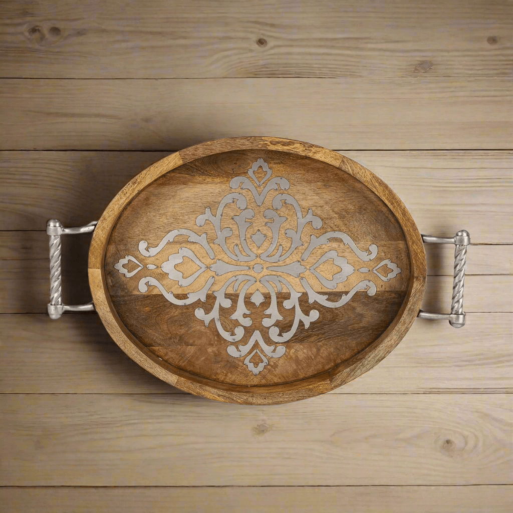 Rustic mango wood serving tray with ornate design and metal handles on a wooden surface, ideal for elegant gatherings.