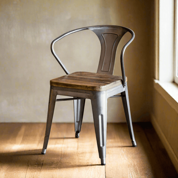 Rustic industrial dining chair with metal frame and reclaimed wood seat in a sunlit room, showcasing a blend of vintage and modern design.