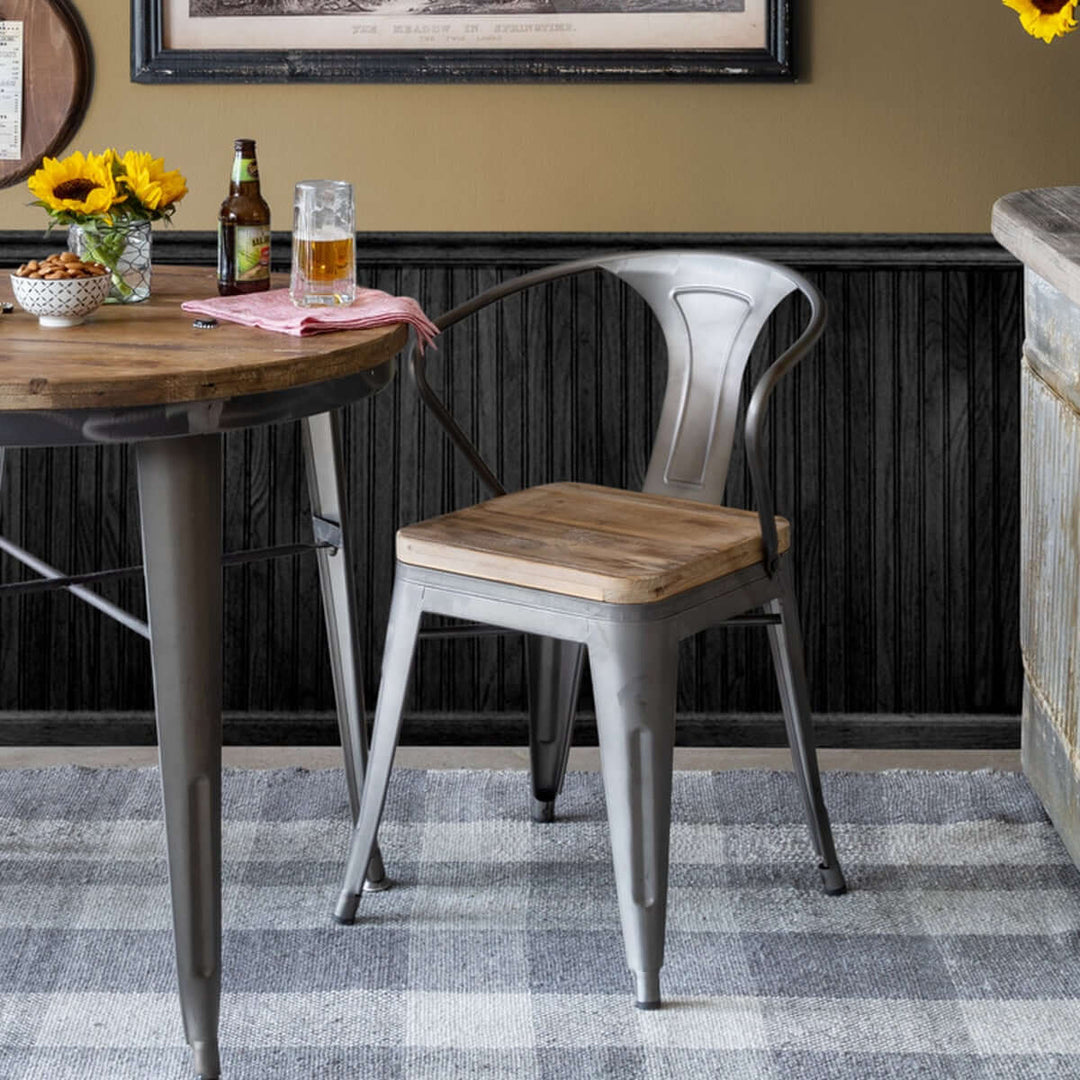 Rustic industrial dining chair with reclaimed wood seat and metal frame in a cozy dining setting, featuring sunflowers and a wooden table.