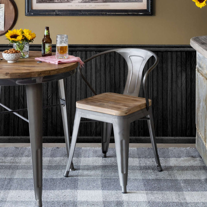 Rustic industrial dining chair with reclaimed wood seat and metal frame in a cozy dining setting, featuring sunflowers and a wooden table.