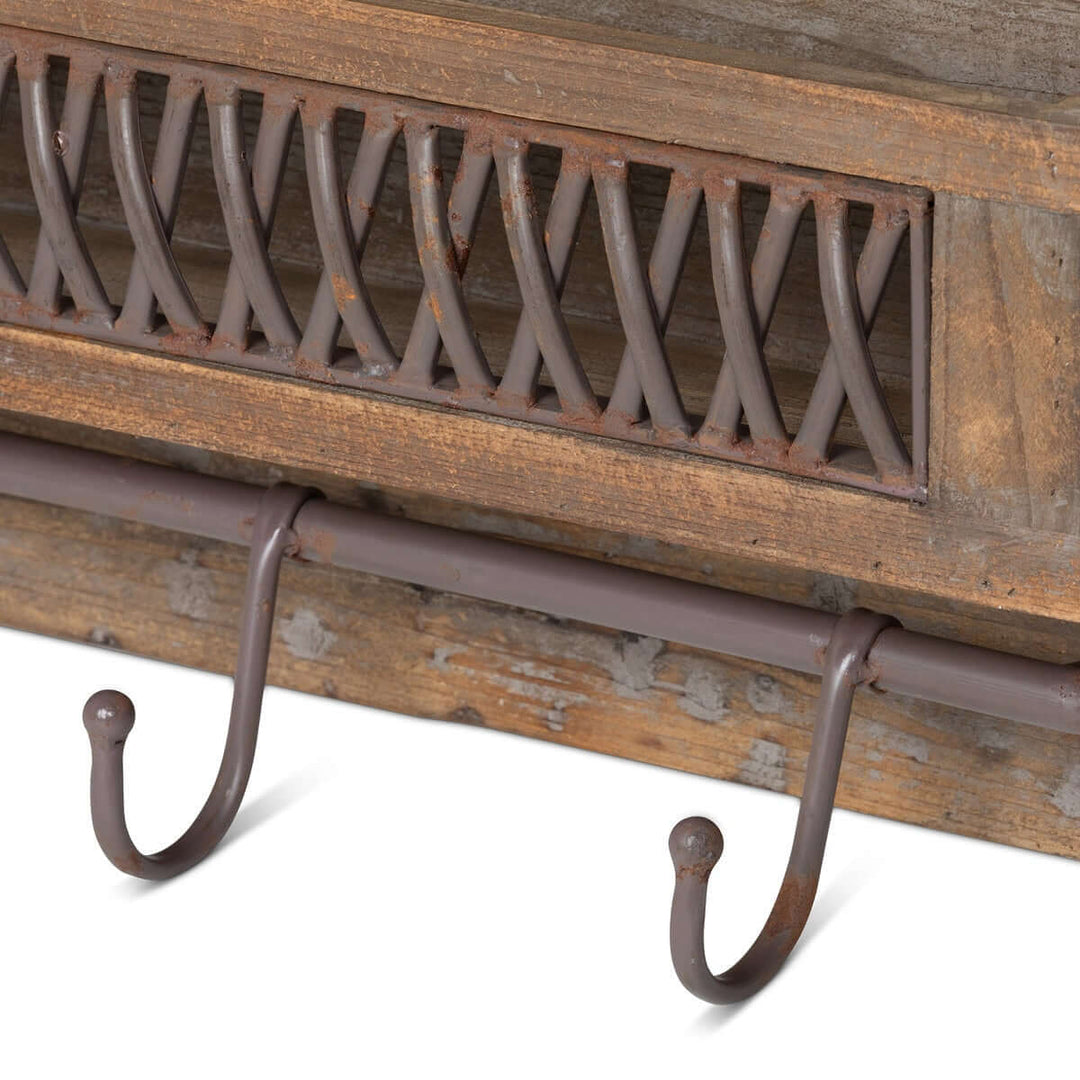 Close-up of farmhouse wall shelf with metal lattice and hooks, showcasing rustic wood and elegant design.