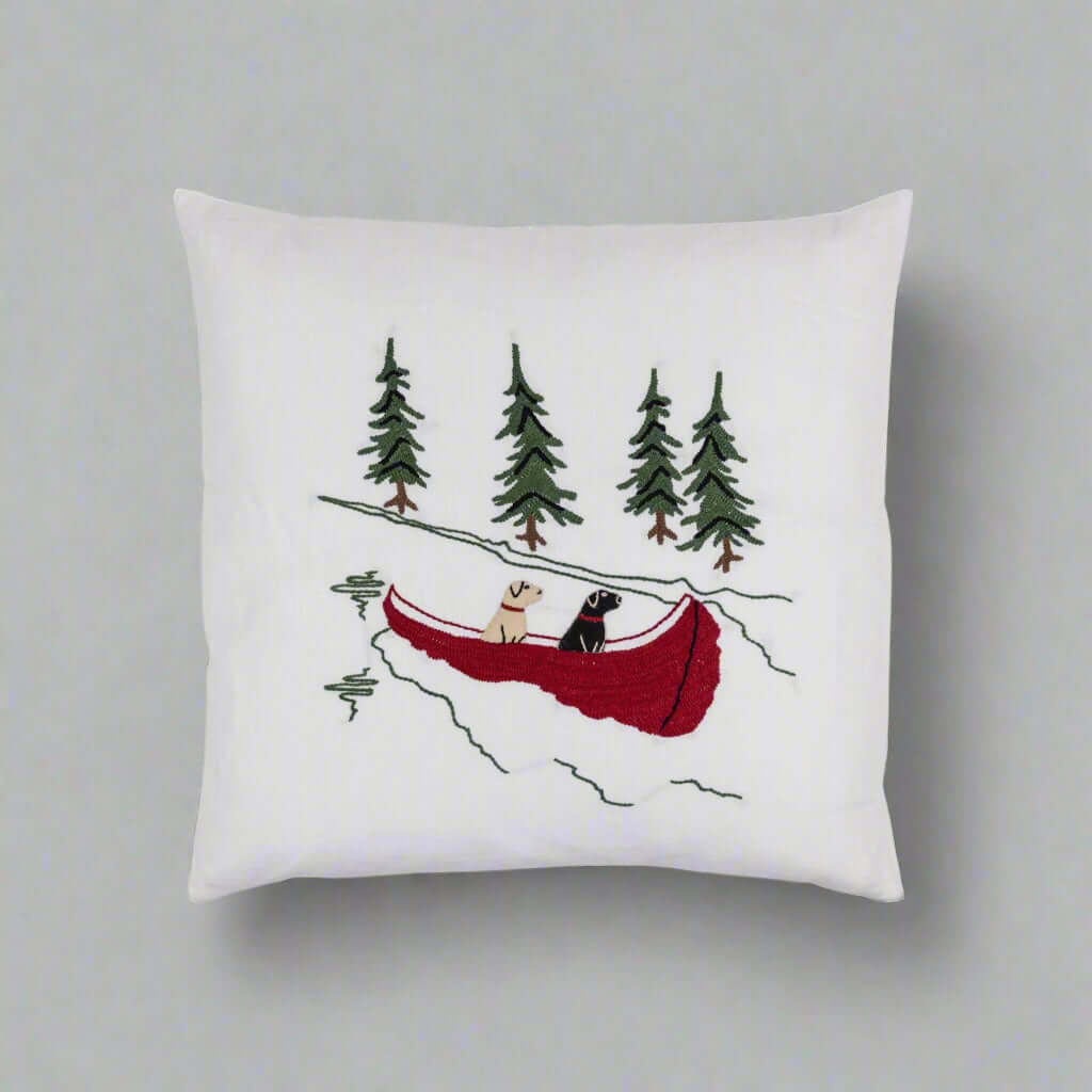 Embroidered Labradors Canoe Porch Pillow with golden and black labs in red canoe, white fabric, evergreen trees, rustic design