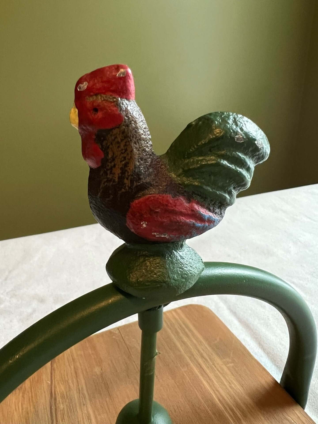 Farmhouse rooster napkin holder with a colorful cast iron rooster and sturdy base, adding rustic charm to any dining space.