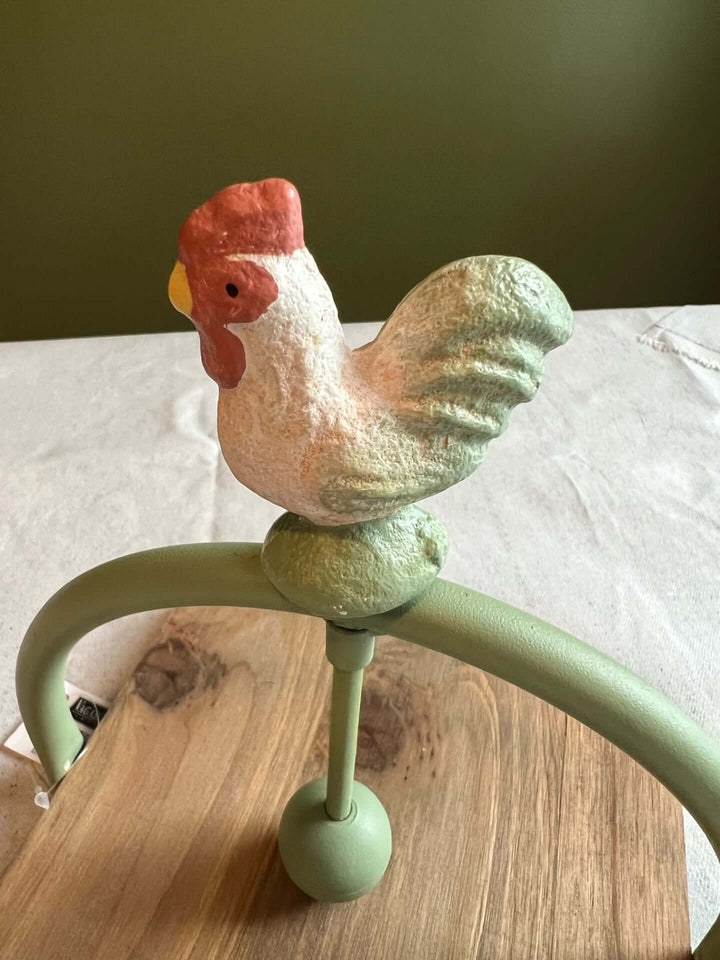 Farmhouse Rooster Napkin Holder featuring a decorative rooster atop a metal arch, adding rustic charm to any dining space.