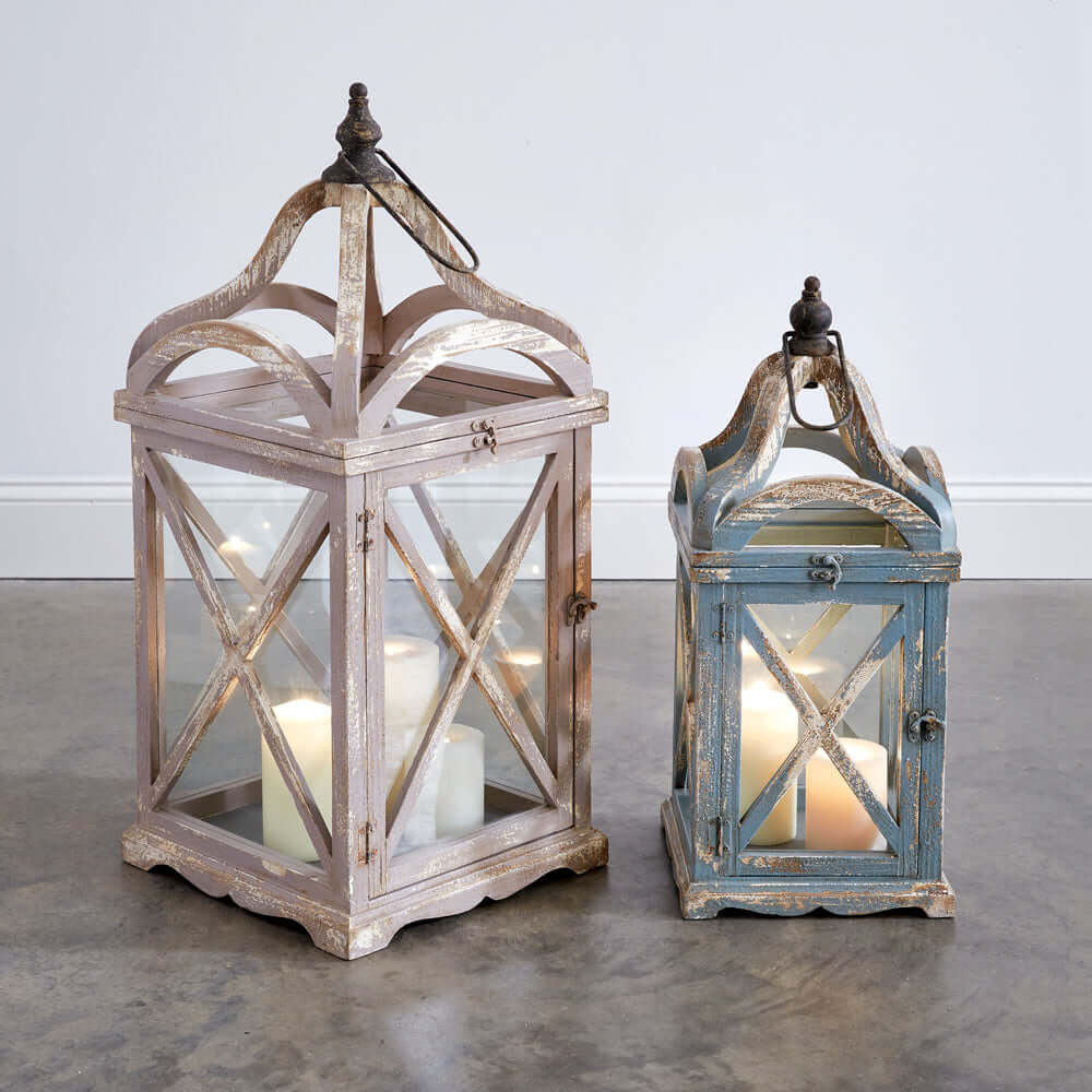 Set of 2 French country lanterns with arched tops and distressed finish, evoking rustic charm and elegance.
