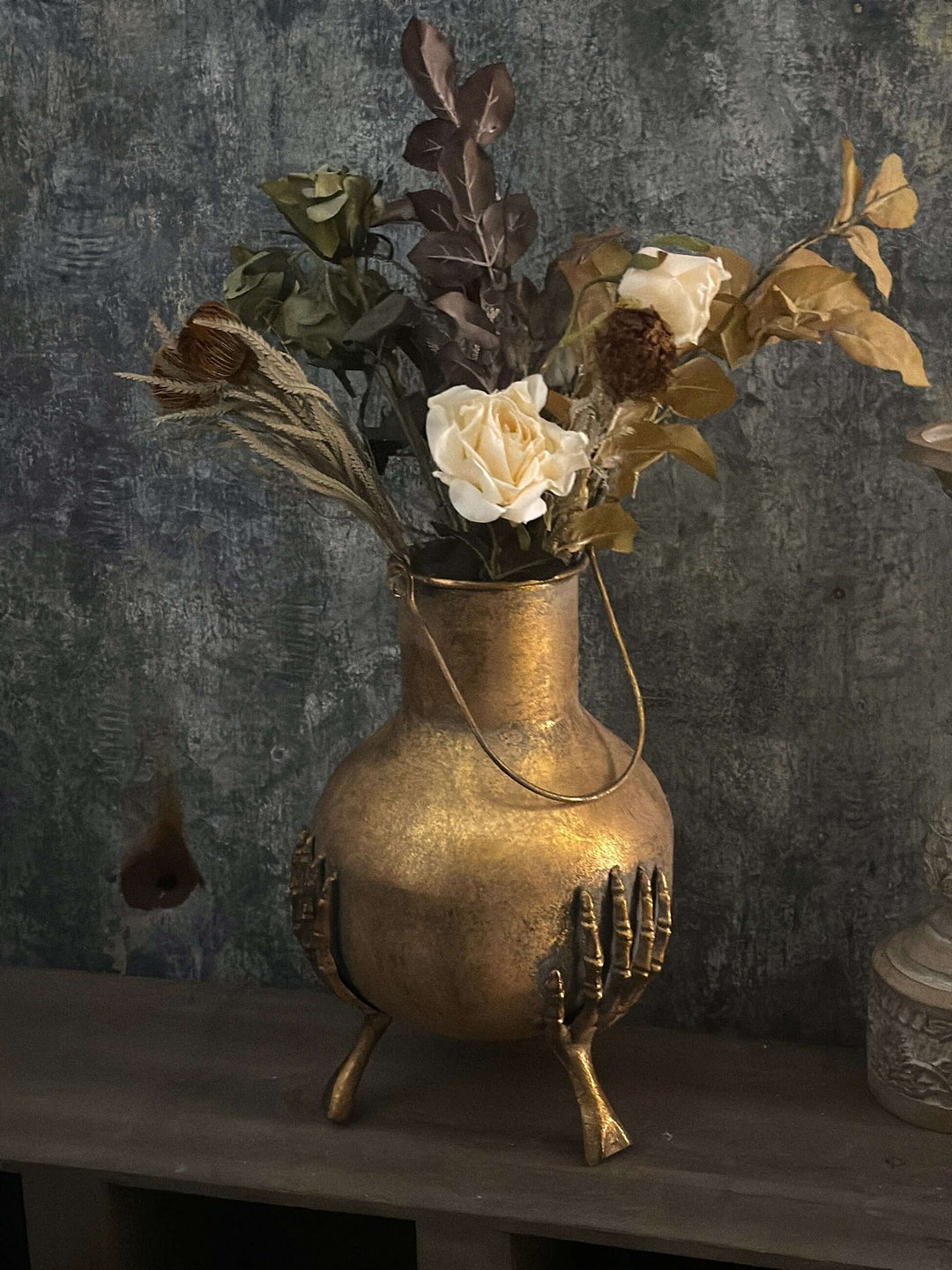 Gothic Skeleton Hands Iron Vase with floral arrangement, antique gold finish, intricate skeleton hand design, Victorian style decor