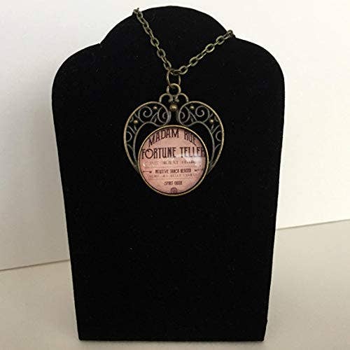 Vintage Fortune Teller Necklace | Antique-Style Pendant with Madam Rue advertisement on black velvet display.