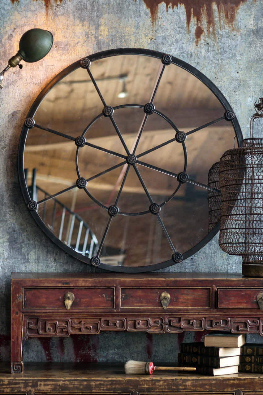Large round industrial grid wall mirror with antique bronze frame, enhancing rustic and vintage home decor.