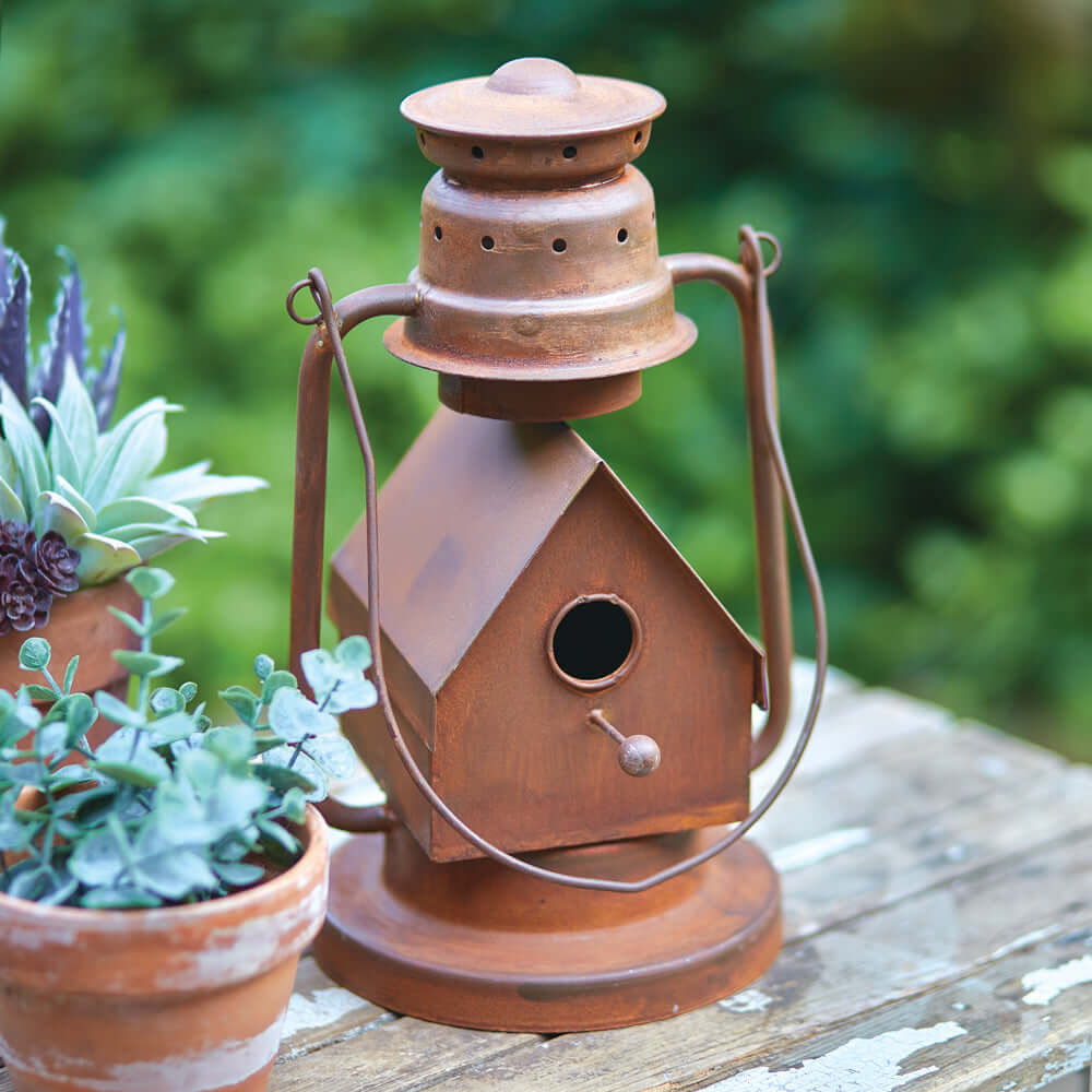 Rustic vintage lantern birdhouse made of weathered metal, styled like an old kerosene lantern with a cozy birdhouse design.