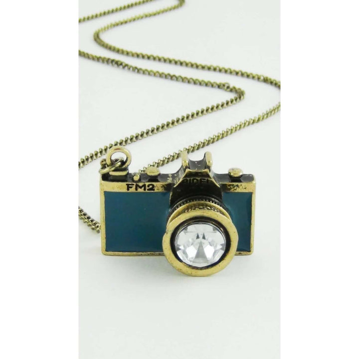 Vintage Camera Pendant Necklace with teal enamel and crystal lens on a brass chain, capturing the charm of old-world photography jewelry.