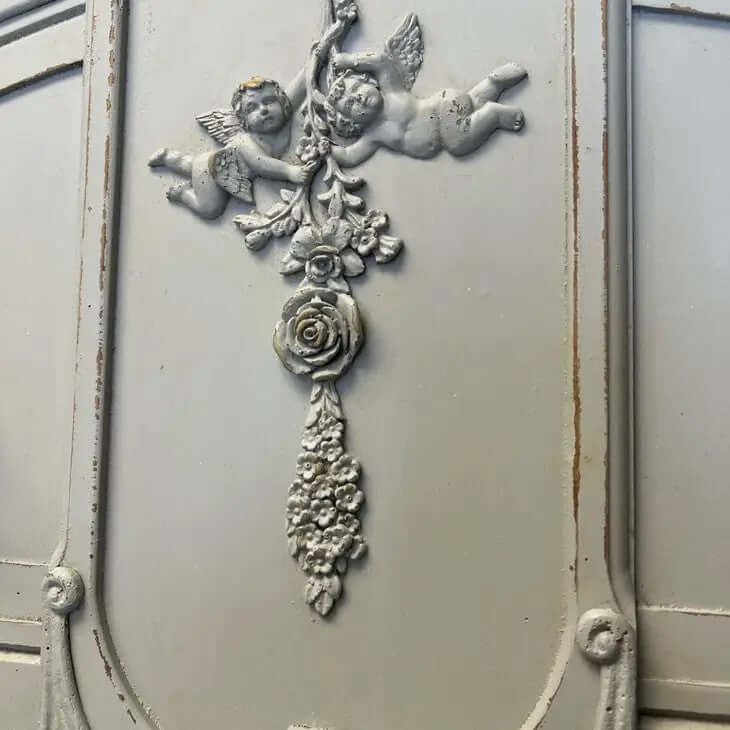 Ornate vintage wall decor featuring cherubs and floral accents, perfect for French country or shabby chic styling.