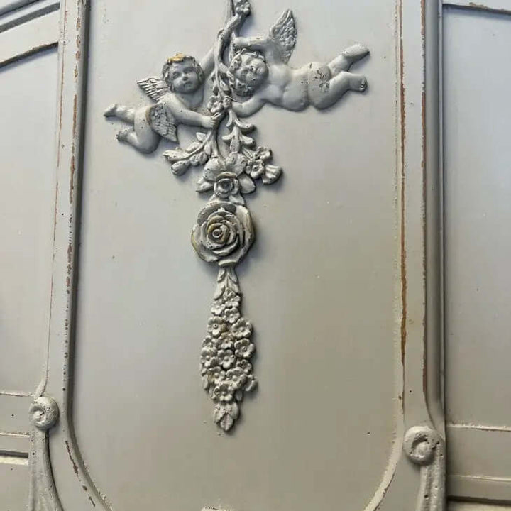 Ornate vintage wall decor featuring cherubs and floral accents, perfect for French country or shabby chic styling.