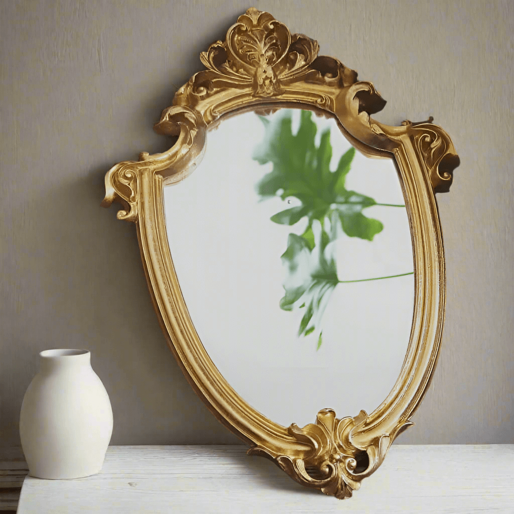 Vintage gold vanity wall mirror with Baroque frame reflecting greenery, enhancing elegant home decor.