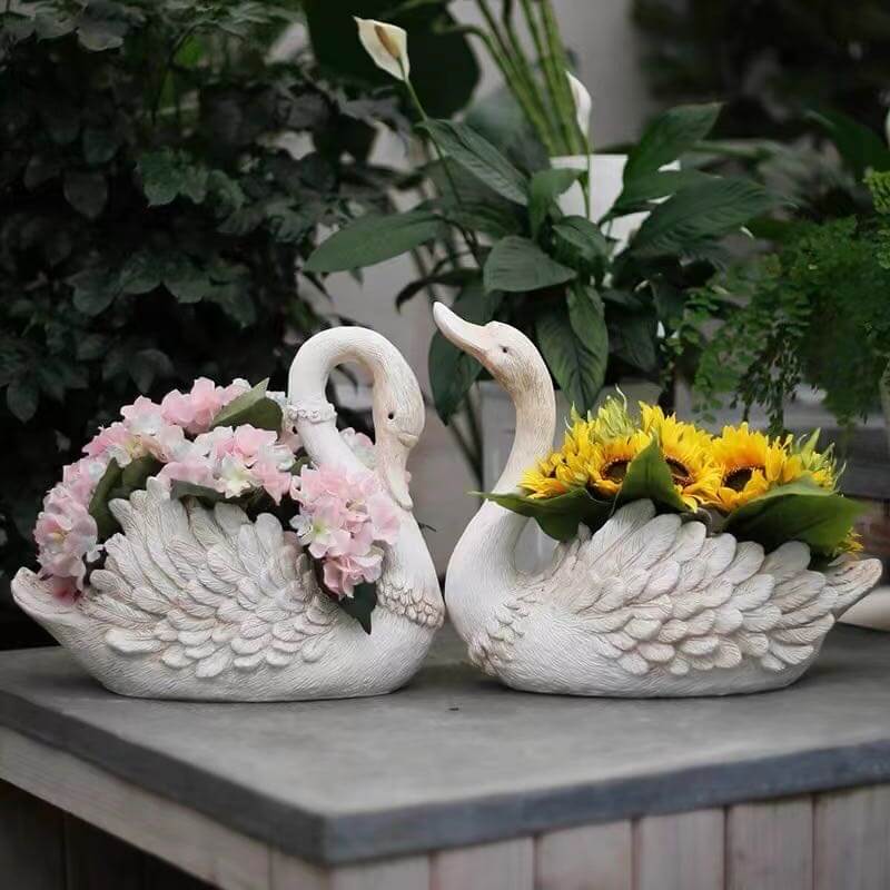 Elegant vintage goose planters with flowers, perfect for garden or indoor decor.