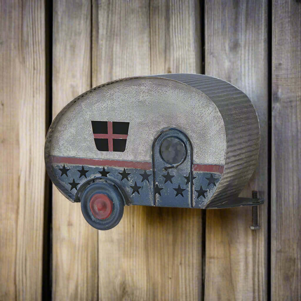 Vintage patriotic camper birdhouse shaped like a retro travel trailer with a weathered finish and Americana design.