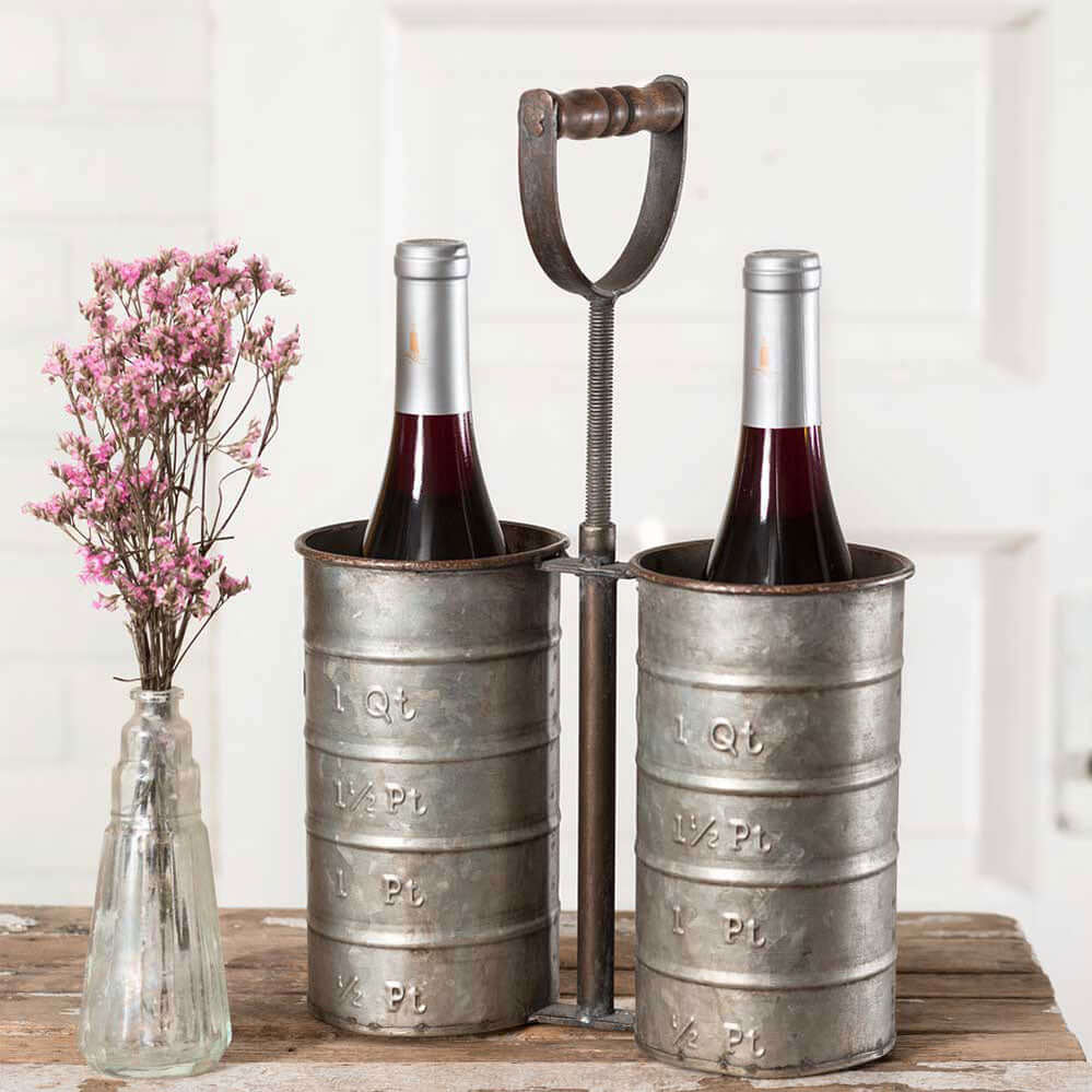 Vintage wine bottle holder in galvanized metal with two wine bottles, featuring embossed measurements for a rustic farmhouse aesthetic.