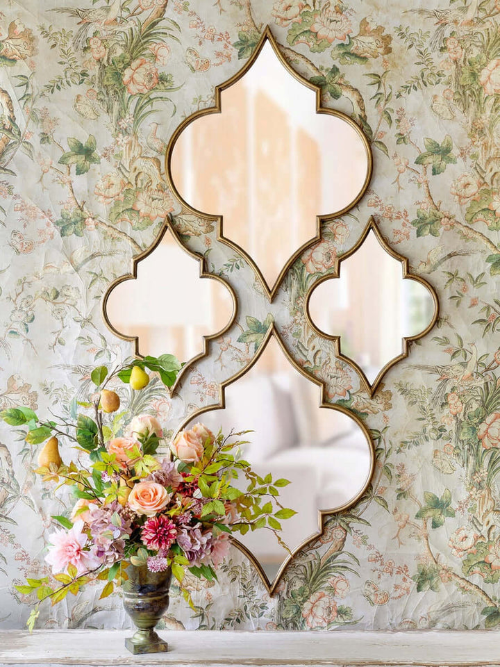 Antique Gold Moroccan Ogee Mirror with floral background, featuring intricate ogee silhouette and vintage charm.