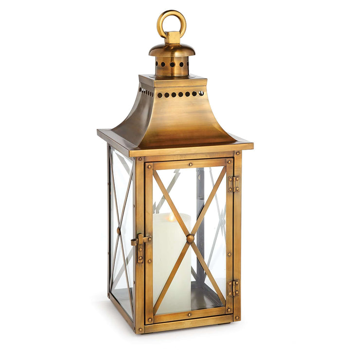 Antique brass lantern with crossbar glass, hanging ring, and aged finish, capturing vintage charm and timeless elegance.