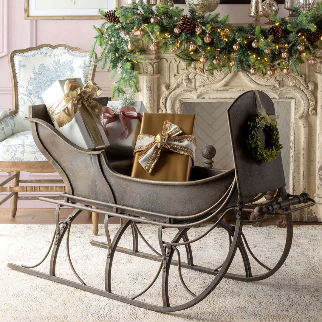 Antique Iron Cutter Sleigh Christmas Décor with gift boxes and wreath in holiday setting