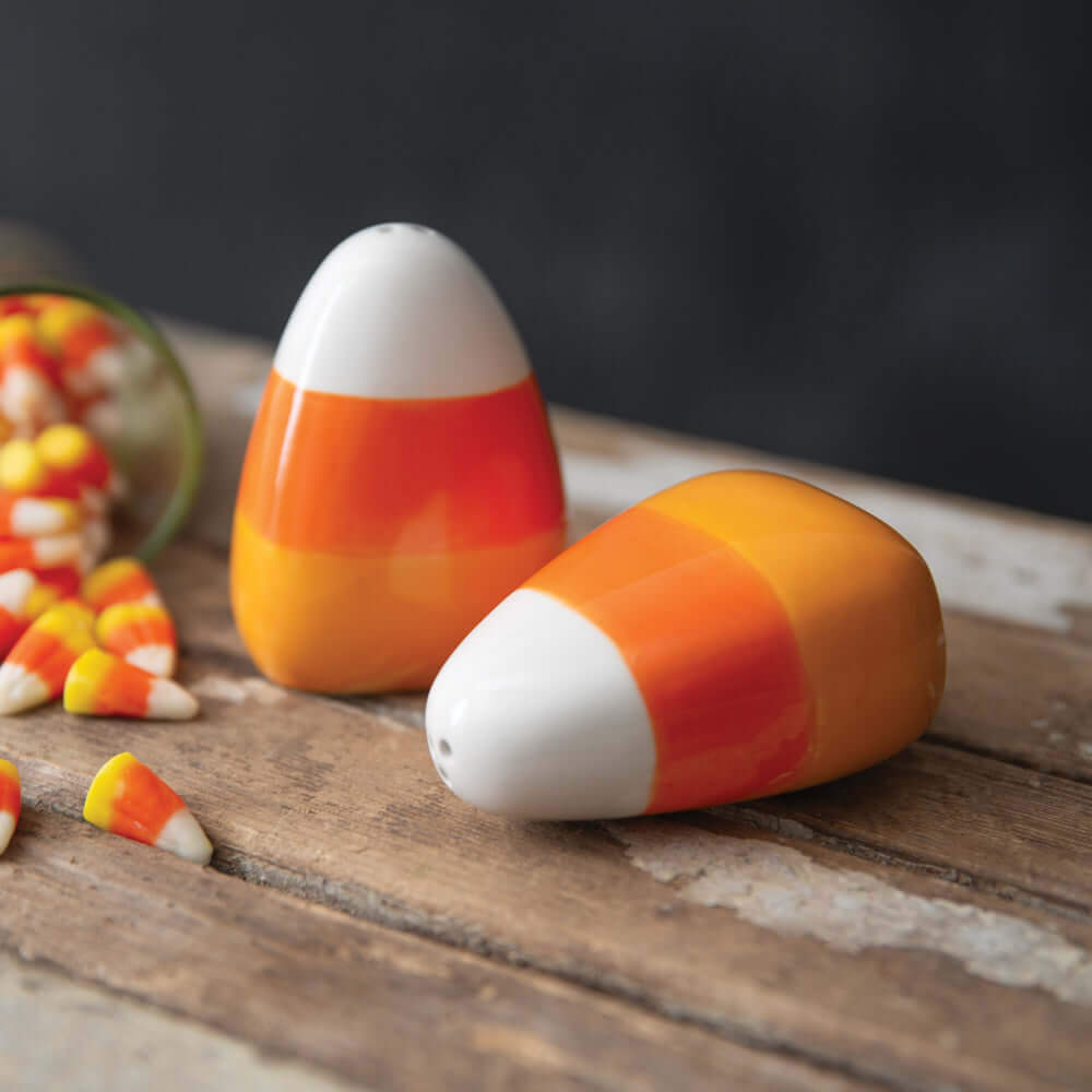 Candy Corn Ceramic Salt and Pepper Shaker Set in white, orange, and yellow hues, evoking autumn nostalgia on a rustic table.