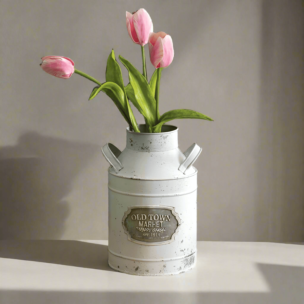 White metal milk can vase with pink tulips, adding vintage charm to farmhouse decor.
