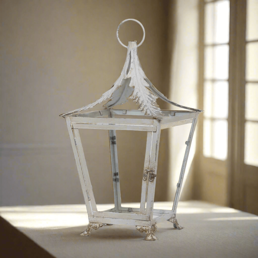 French Country Garden Lantern in Distressed Cream on a table, showcasing vintage iron structure and glass panels, evoking Provence charm.
