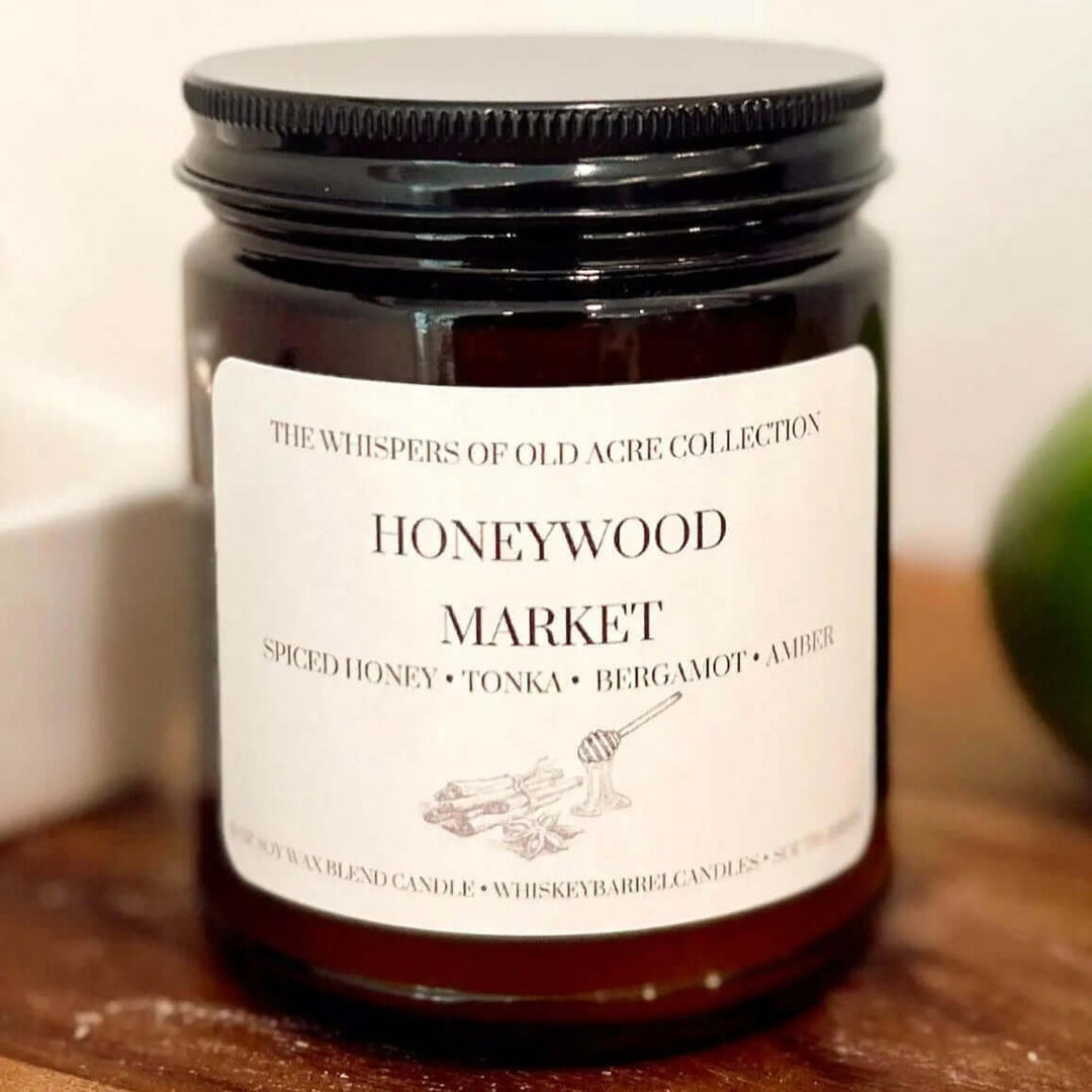 Honeywood Market Scented Candle: Spiced Honey, Tonka & Amber jar on a wooden surface.