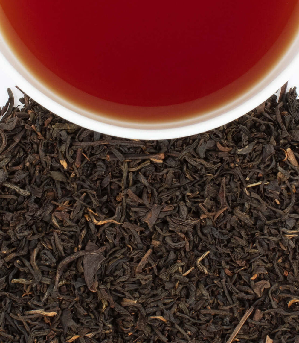 Cup of brewed black tea with loose tea leaves from Murder on the Orient Express Tea Tin (20 Sachets) by Harney & Sons.