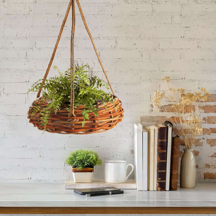 Rattan hanging basket with fern, displayed against a rustic brick wall, adding greenery to a cozy interior.