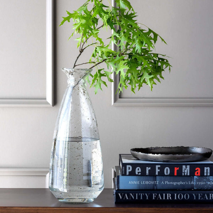 Recycled Glass Coastal Vase with leafy branch on bookshelf, embodying coastal elegance and sustainability.