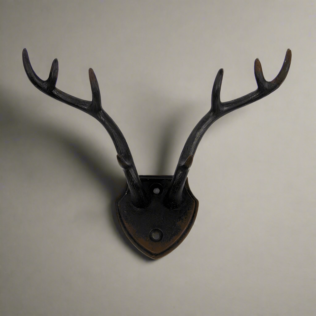 Rustic antler wall hook with shield backplate, ideal for lodge décor and rustic charm in home accents.