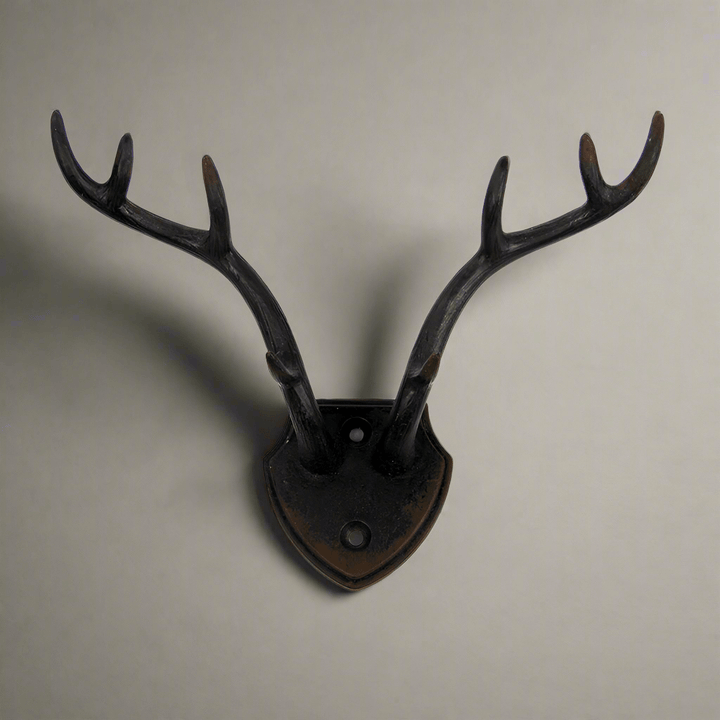 Rustic antler wall hook with shield backplate, ideal for lodge décor and rustic charm in home accents.