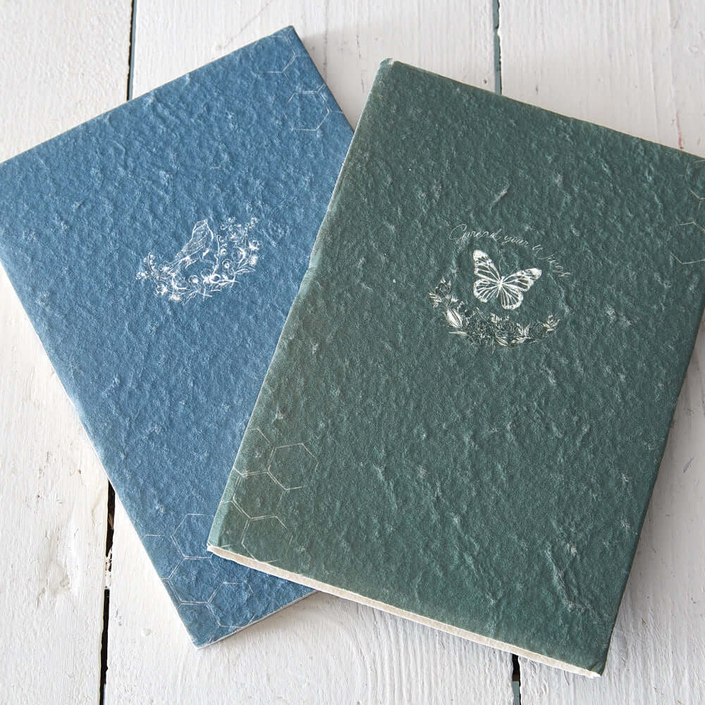Vintage Cottagecore Handmade Journals (Set of 2) with textured covers on a white wooden table.