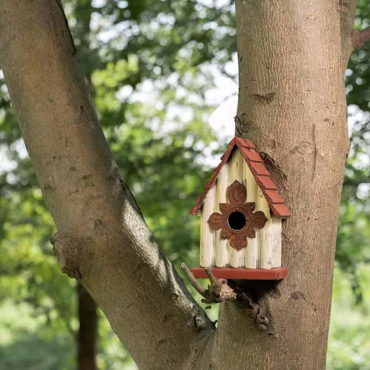 Vintage-Inspired Wooden Birdhouse with Terracotta Roof hanging on a tree