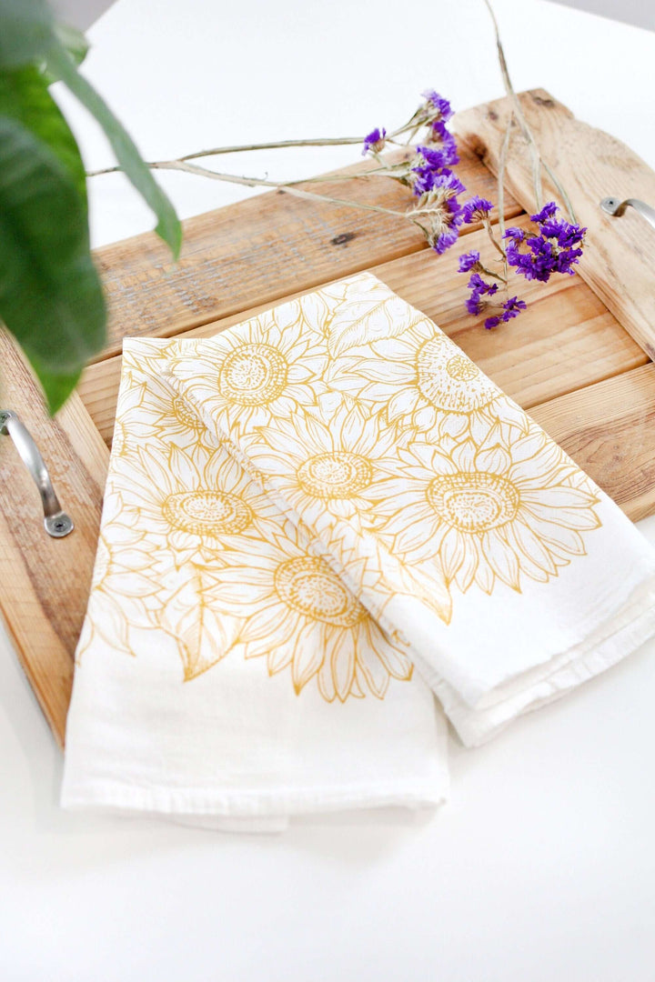 Vintage Sunflower Tea Towel with golden sunflower design on a cutting board, evoking vintage farmhouse style with watercolor artistry.