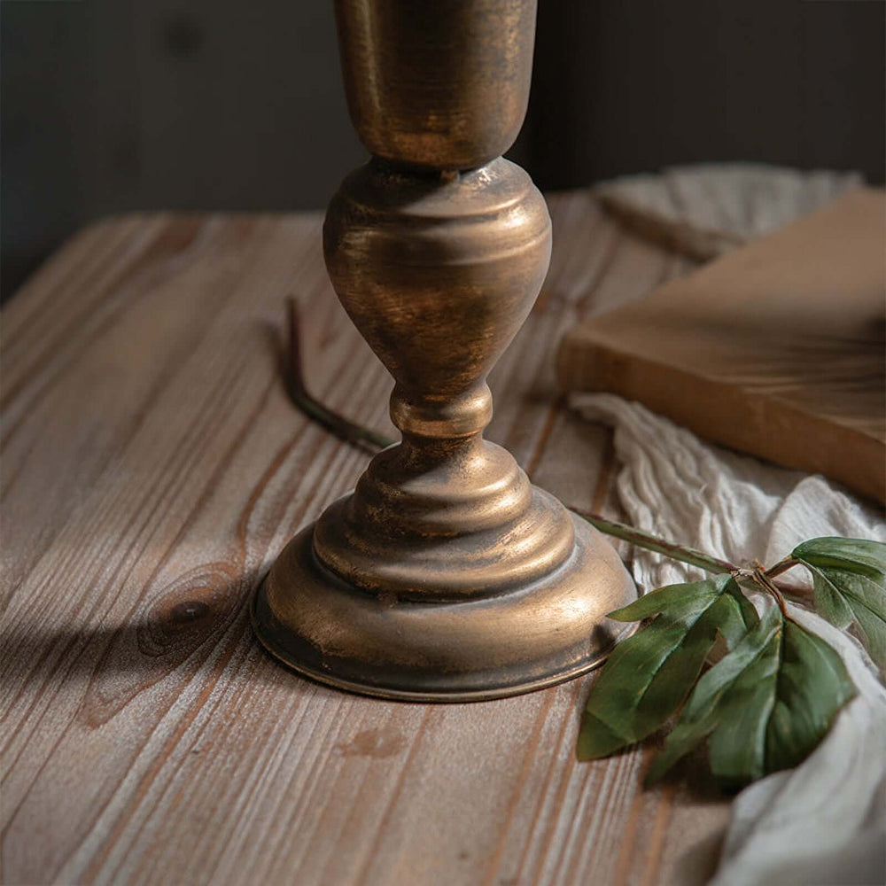 Close-up of vintage gold trumpet vase base on rustic wood table with greenery, elegant floral arrangement decor