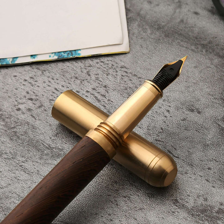 Vintage Wood and Brass Fountain Pen | The Hemmingway with cap displayed on textured surface.