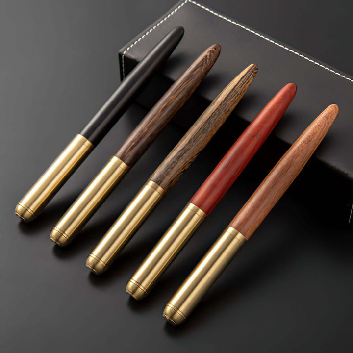 Vintage Wood and Brass Fountain Pen | The Hemmingway - a collection of five elegant handmade pens displayed on a black surface.